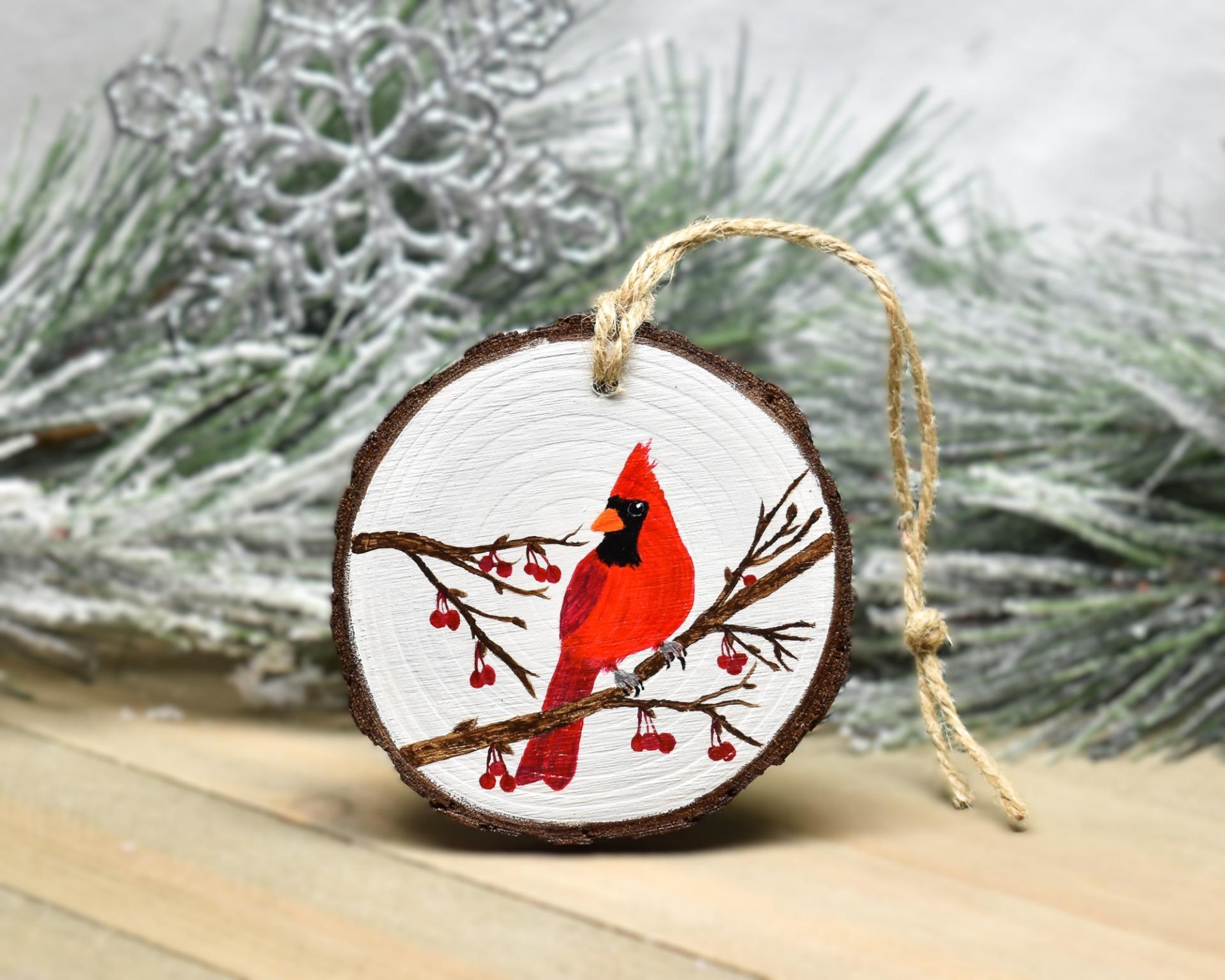 An acrylic painting of a male northern cardinal perched on a bare tree branch with red berries at covecreekphotography.com.