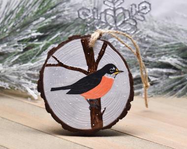 A wood slice Christmas ornament with a hand-painted American robin in falling snow at covecreekphotography.com.