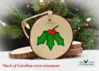 A hand-painted holly sprig with red berries hand-painted on a wood slice ornament at covecreekphotography.com.