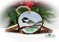 A wood slice Christmas ornament with a hand-painted Carolina chickadee available at www.covecreekphotography.com.