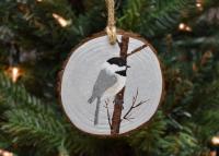 A hand-painted chickadee in the snow wood slice Christmas ornament at Cove Creek Photography.