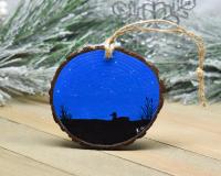 A hand-painted loon and marsh silhouette against a starry night sky on a three inch wood slice at covecreekphotography.com.