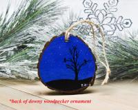 A hand-painted starry winter night with a black silhouette of birds in a tree on the back of a woodpecker wood slice ornament at covecreekphotography.com.