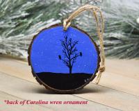 A hand-painted wood slice ornament with a starry night sky and bird and tree silhouette at Cove Creek Photography.