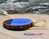 An image of the side of a hand-painted Christmas ornament displaying the bark and thickness of the wood slice at Cove Creek Photography. 