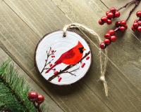 A handmade northern cardinal wood slice Christmas ornament at Cove Creek Photography.
