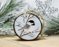 A Carolina chickadee hand-painted on a winter scene wood slice ornament at Cove Creek Photography.