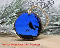 A hand-painted wood slice Christmas ornament with a night sky and a silhouette of a bird at Cove Creek Photograpy.