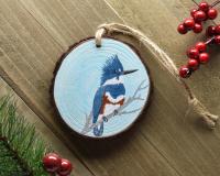 A handmade wood slice ornament with a hand-painted belted kingfisher at covecreekphotography.com. 