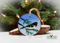 A hand-painted rose-breasted grosbeak on a wood slice ornament at www.covecreeekphotography.com.