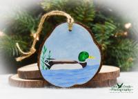 A hand-painted mallard on a pear shaped wood slice Christmas ornament at Cove Creek Photography.