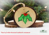 Hand-painted holly leaves and red berries on the back of a nuthatch wood slice ornament at covecreekphotography.com.