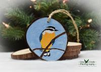 An acrylic painting of a red-breasted nuthatch on a 3.5 inch wood slice Christmas ornament at Cove Creek Photography.