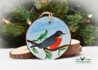 A handmade wood slice Christmas ornament with a hand-painted American Robin at Cove Creek Photography.