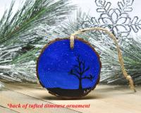 A hand-painted starry night sky with silhouettes on the back of a wood slice ornament at Cove Creek Photography.
