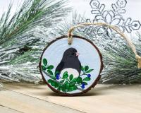An acrylic painting of a dark-eyed junco on a wood slice ornament at covecreekphotography.com.