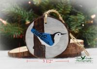 An image of a white-breasted nuthatch wood slice Christmas ornament with size dimensions at covecreekphotography.com.