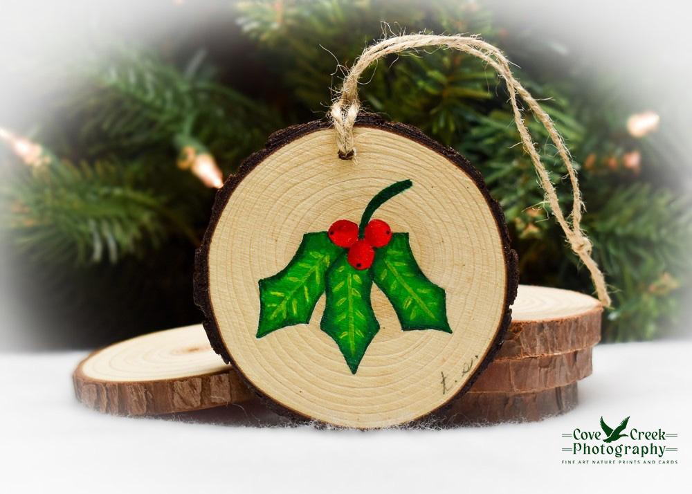 Hand-painted holly leaves with three red berries on the back of a northern cardinal ornament at covecreekphotography.com.