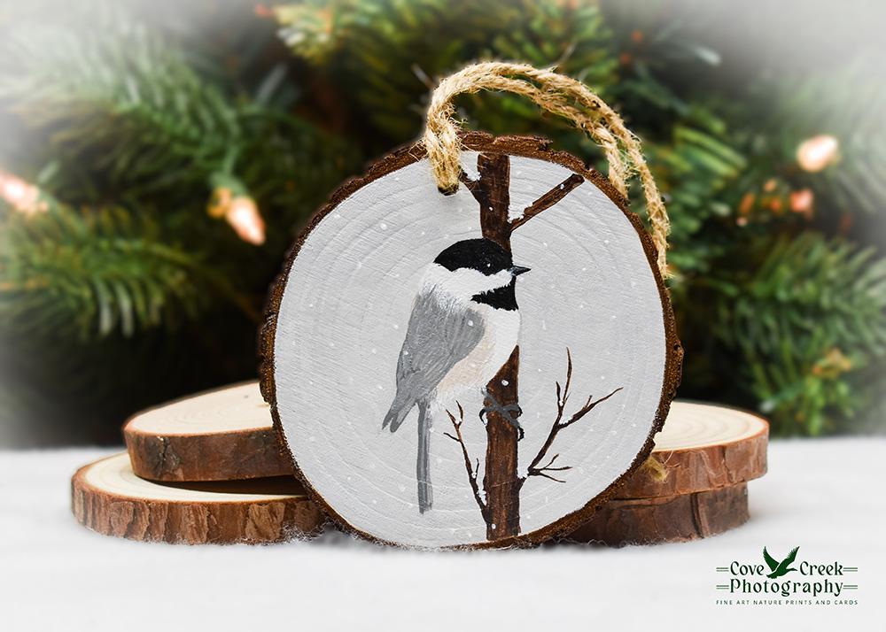 A handmade Christmas ornament with a hand-painted bird on a wood slice at covecreekphotography.com.