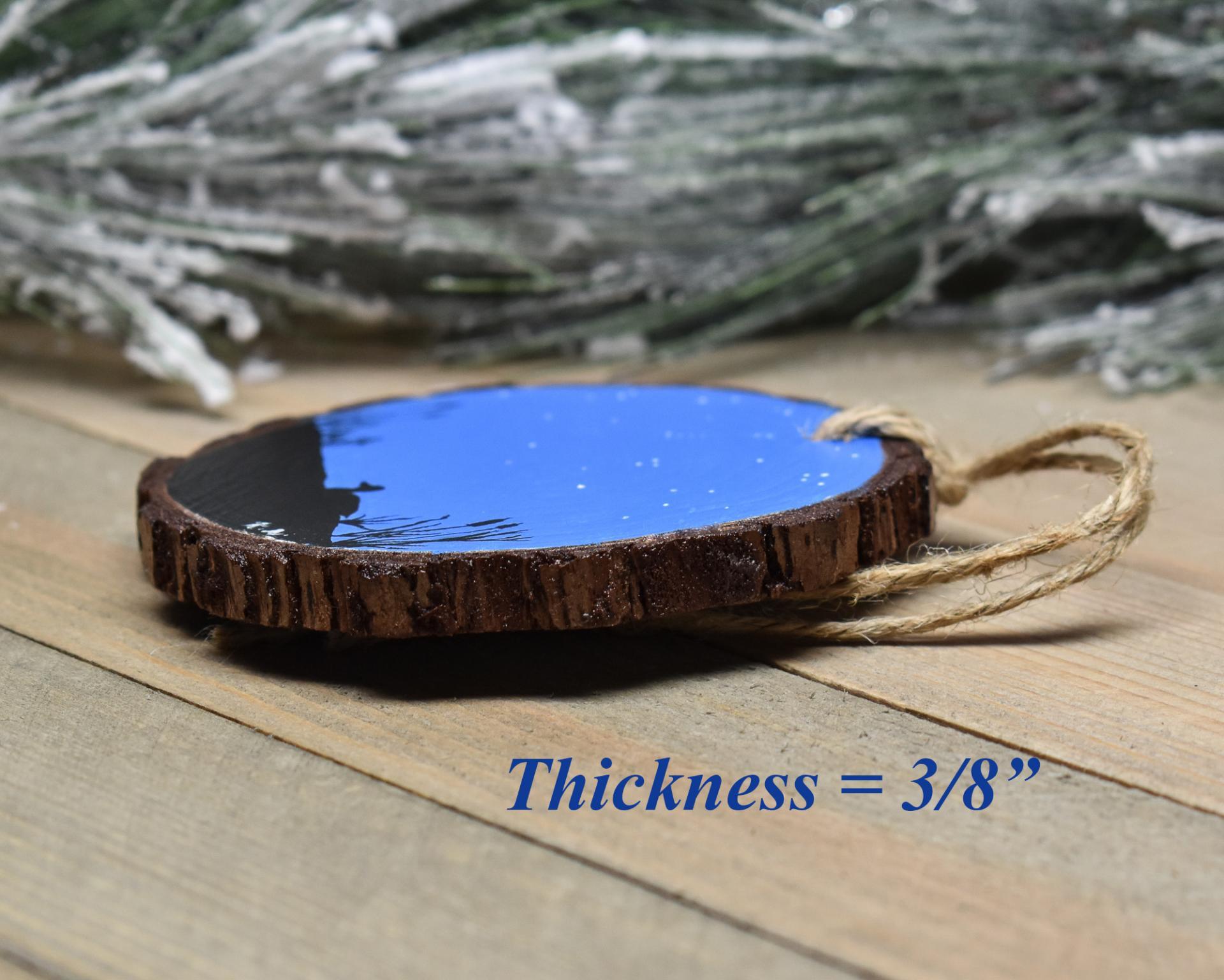 An image showing the thickness of a handmade wood slice Christmas ornament at Cove Creek Photography.