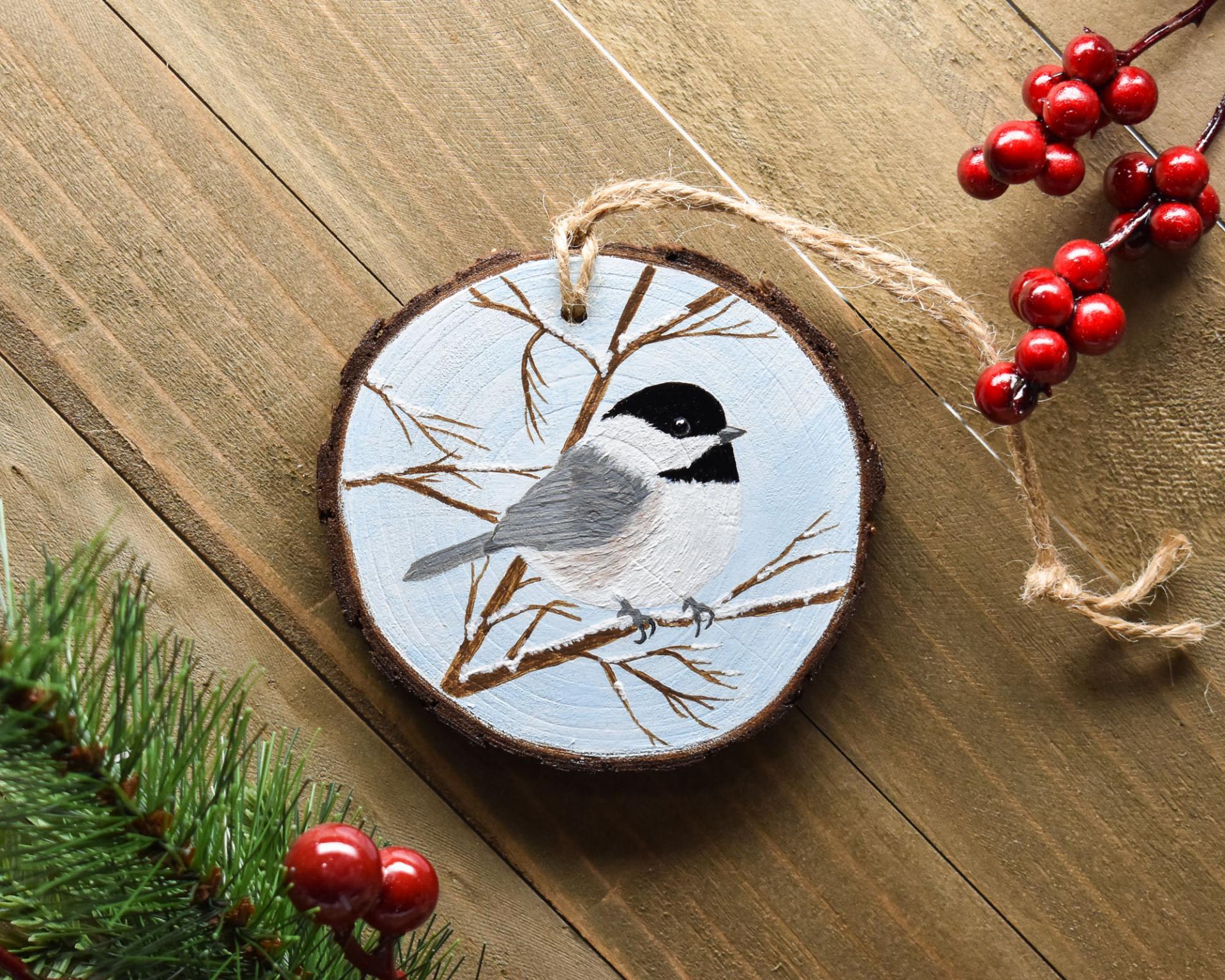 A handmade chickadee wood slice Christmas ornament at covecreekphotography.com.