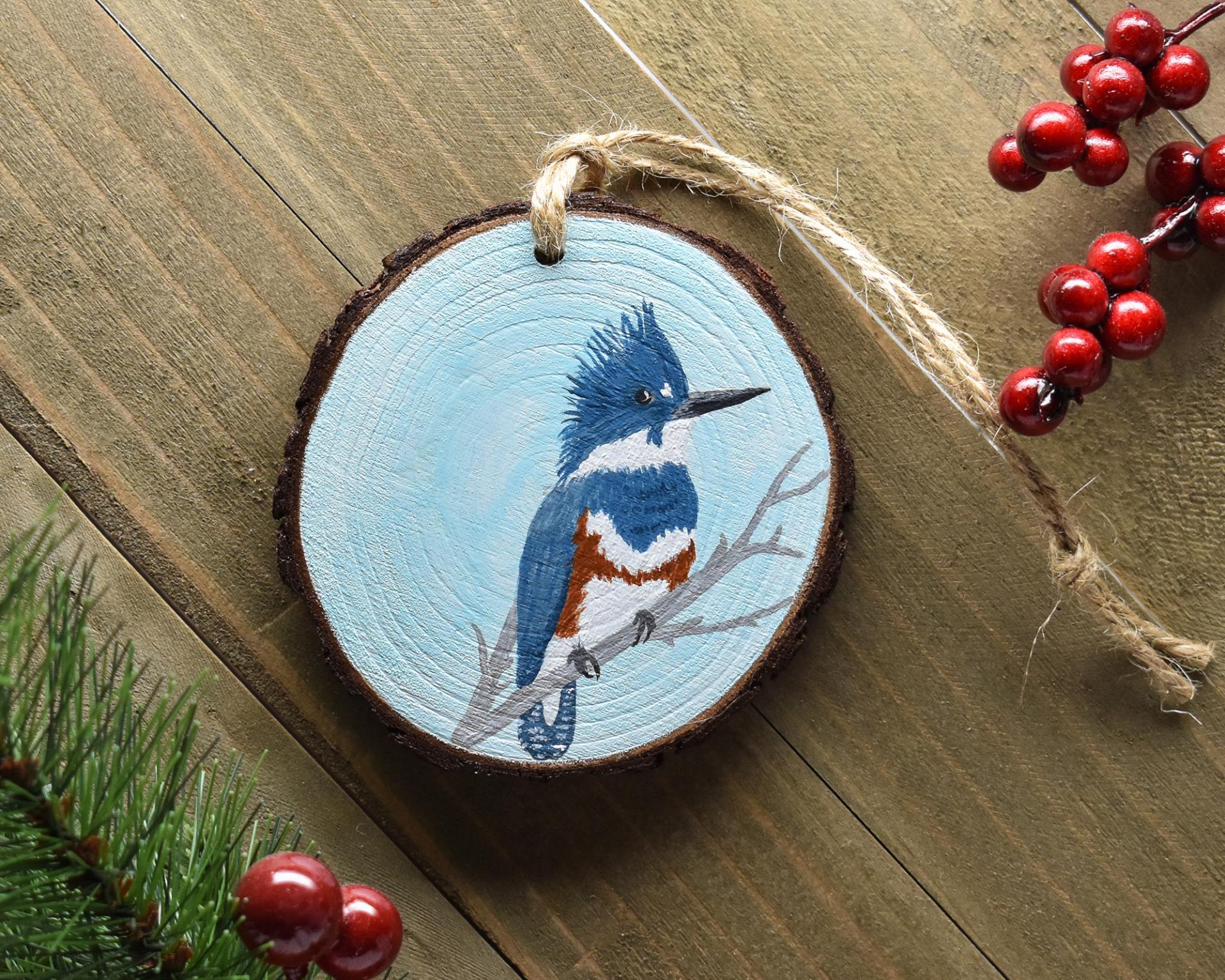 A handmade wood slice ornament with a hand-painted belted kingfisher at covecreekphotography.com. 