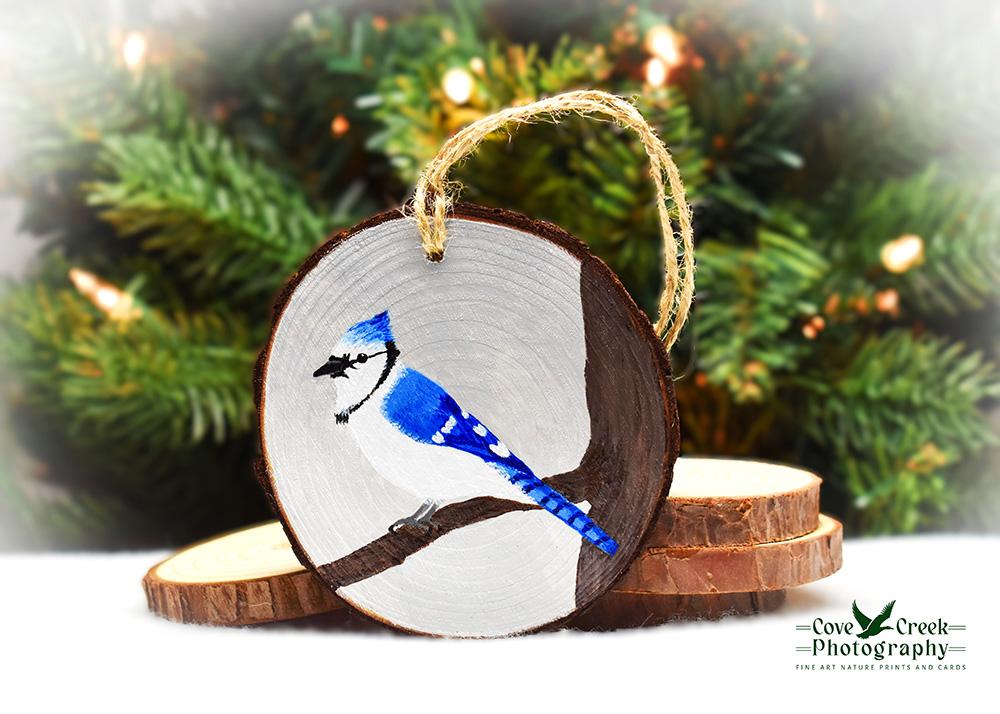 A handmade wood slice Christmas ornament with a hand-painted offered at www.covecreekphotography.com.blue jay