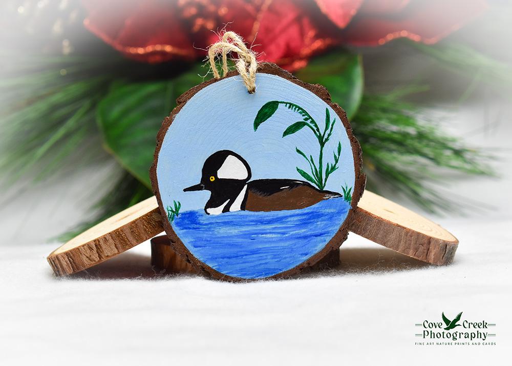 A hand-painted wood slice with a hooded merganser at Cove Creek Photography.