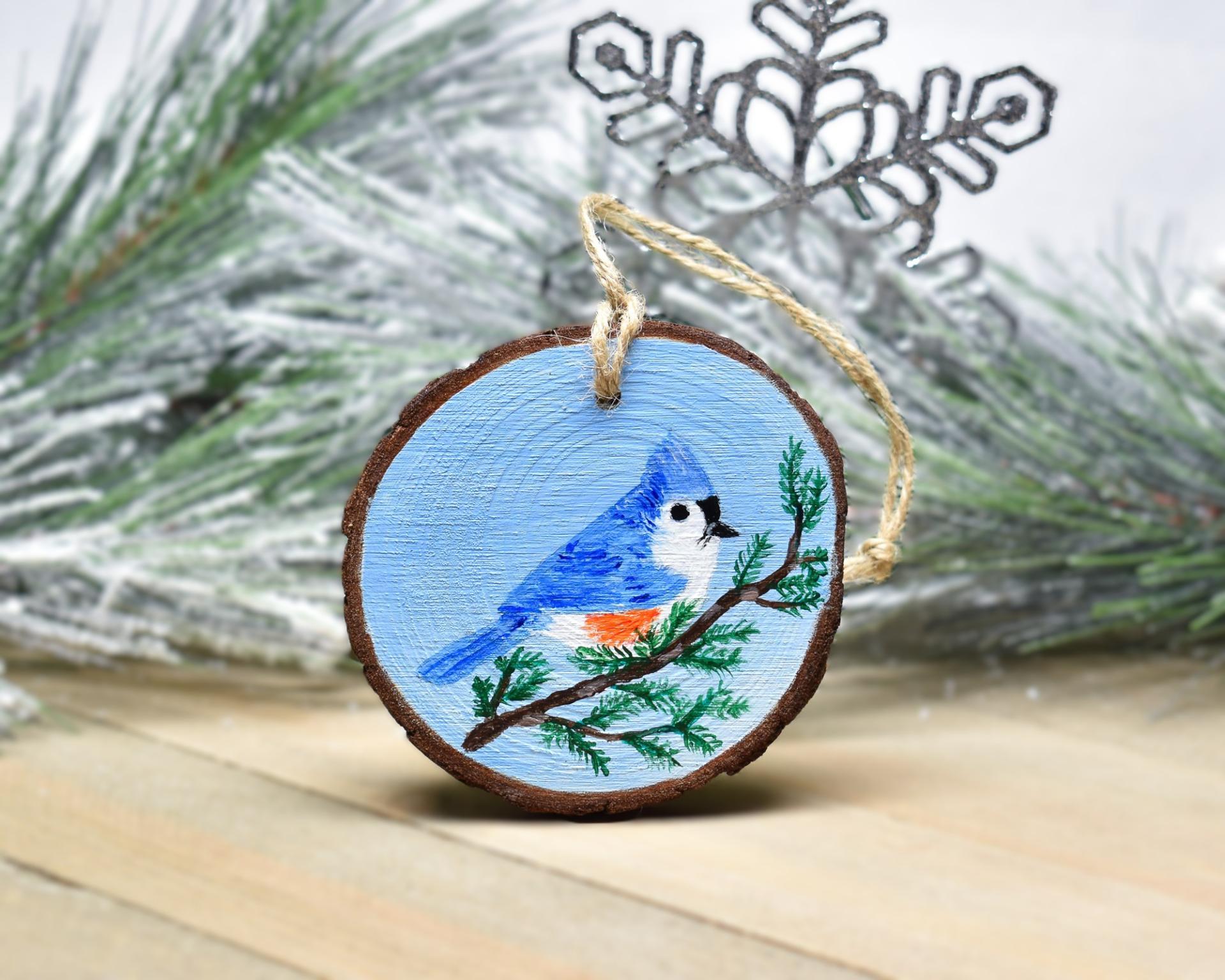 An acrylic painting of a tufted titmouse on a three inch wood slice ornament at Cove Creek Photography.