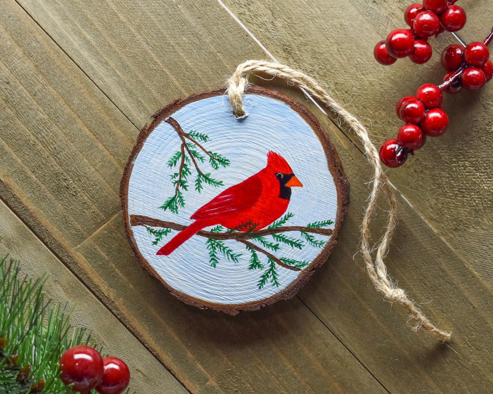 A handmade northern cardinal wood slice Christmas ornament at Cove Creek Photography.