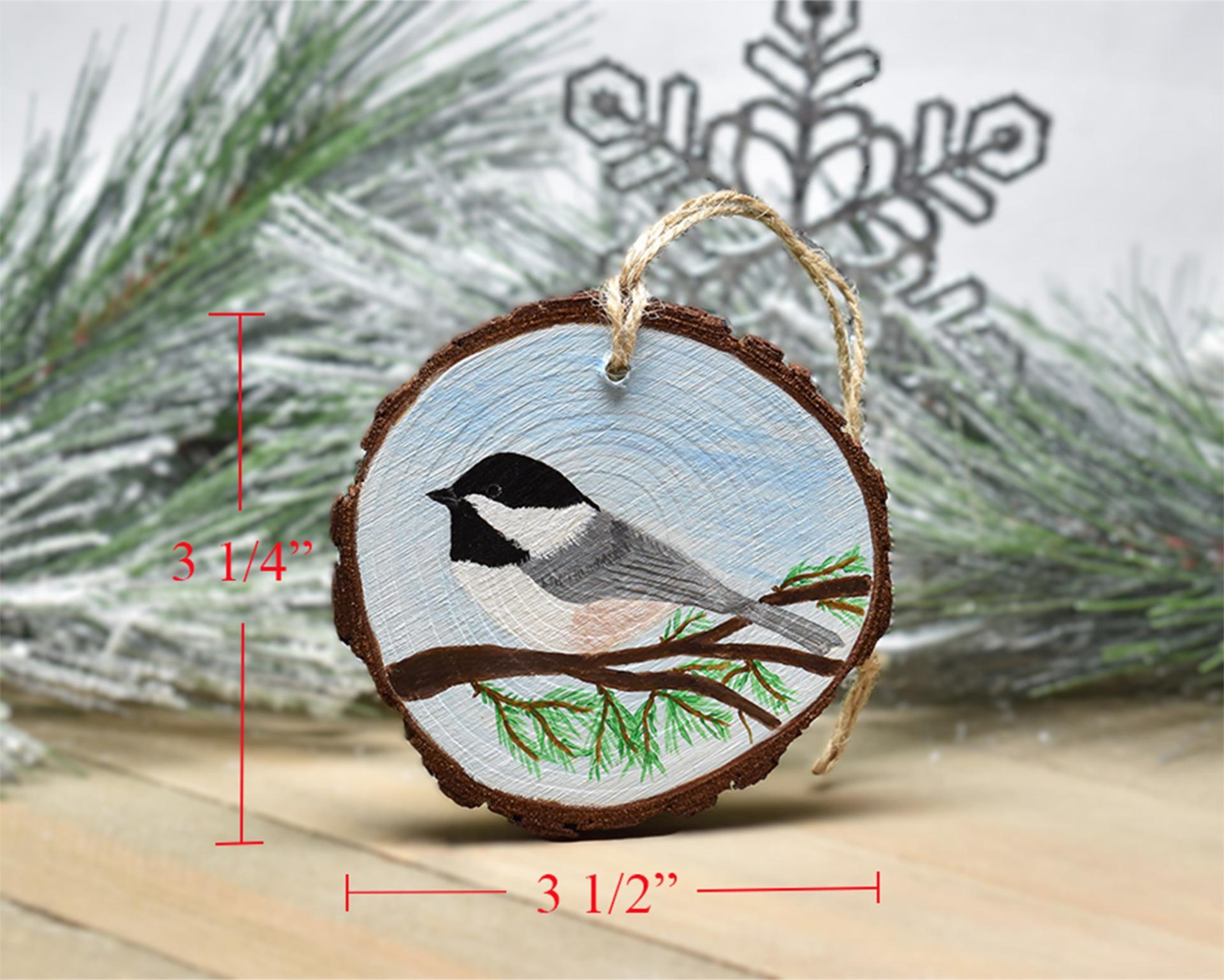 A handmade chickadee wood slice ornament with the measurements displayed on each side at covecreekphotography.com.