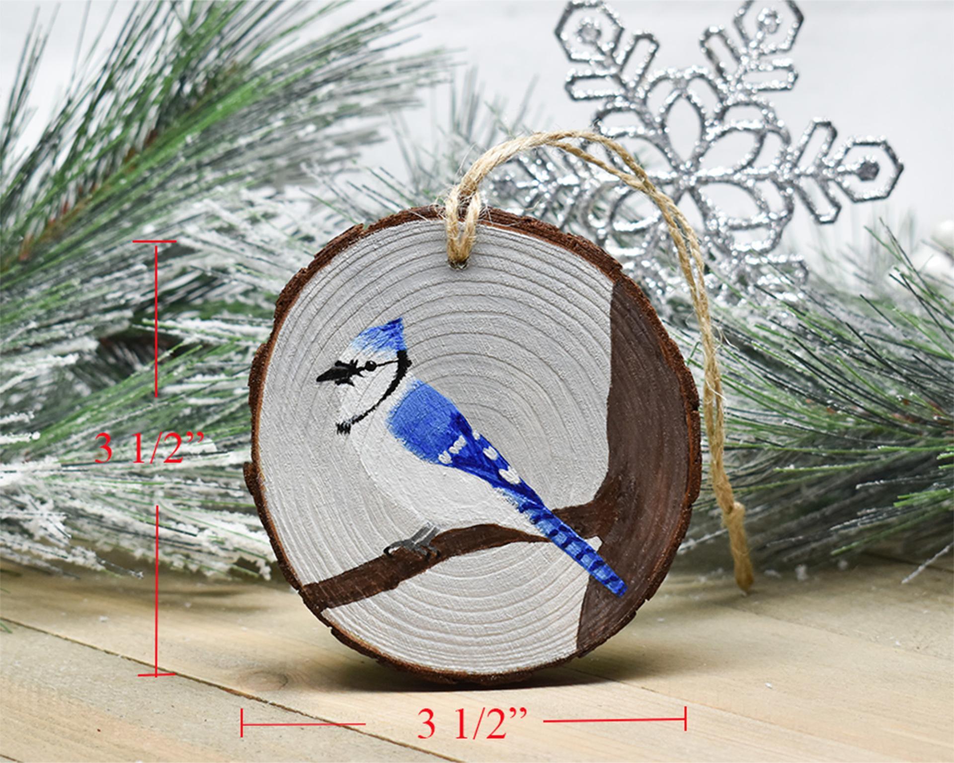 An image of a hand-painted blue jay on a wood slice Christmas ornament with added measurements at Cove Creek Photography.