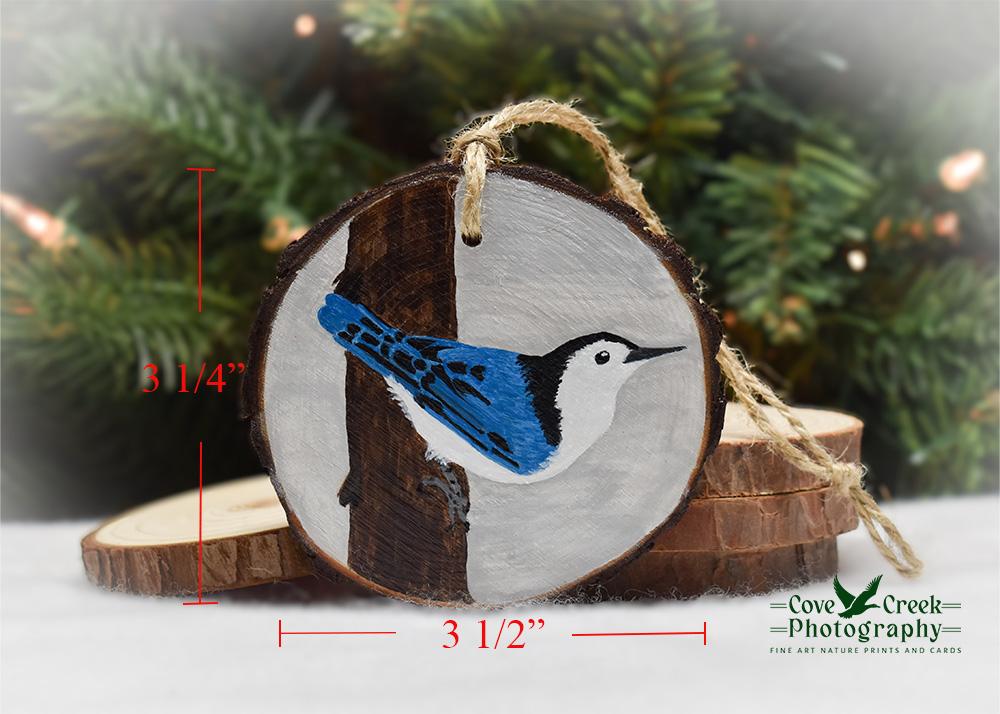 An image of a white-breasted nuthatch wood slice Christmas ornament with size dimensions at covecreekphotography.com.