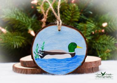 A hand-painted mallard on a pond wood slice Christmas ornament at covecreekphotography.com.