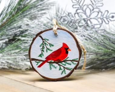 A bright red northern cardinal hand-painted on a wood slice at Cove Creek Photography.