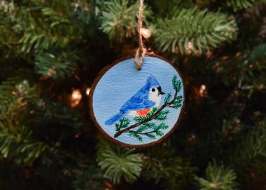 A hand-painted tufted titmouse on a wood slice Christmas ornament available at covecreekphotography.com.