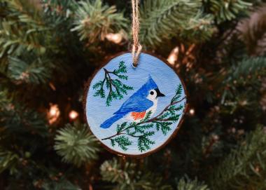 A tufted titmouse on a cedar branch hand-painted on a wood slice available for purchase at Cove Creek Photography.