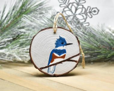 An acrylic painting of a female belted kingfisher on a wood slice Christmas ornament at covecreekphotography.com.
